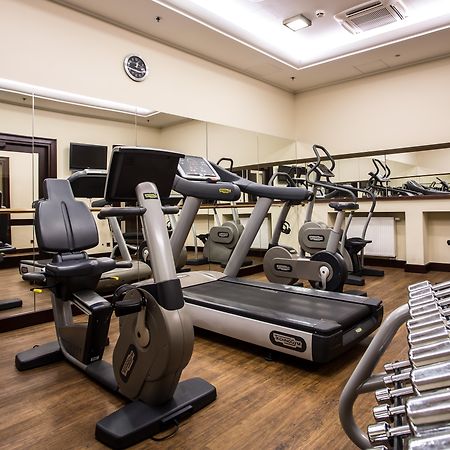 Radisson Blu Hotel, กดัญสก์ ภายนอก รูปภาพ The photo displays a small gym or fitness room. The room features various exercise equipment, including a treadmill, an elliptical machine, and a set of dumbbells arranged on a rack. There are mirrors on the wall, which help create a sense of space a
