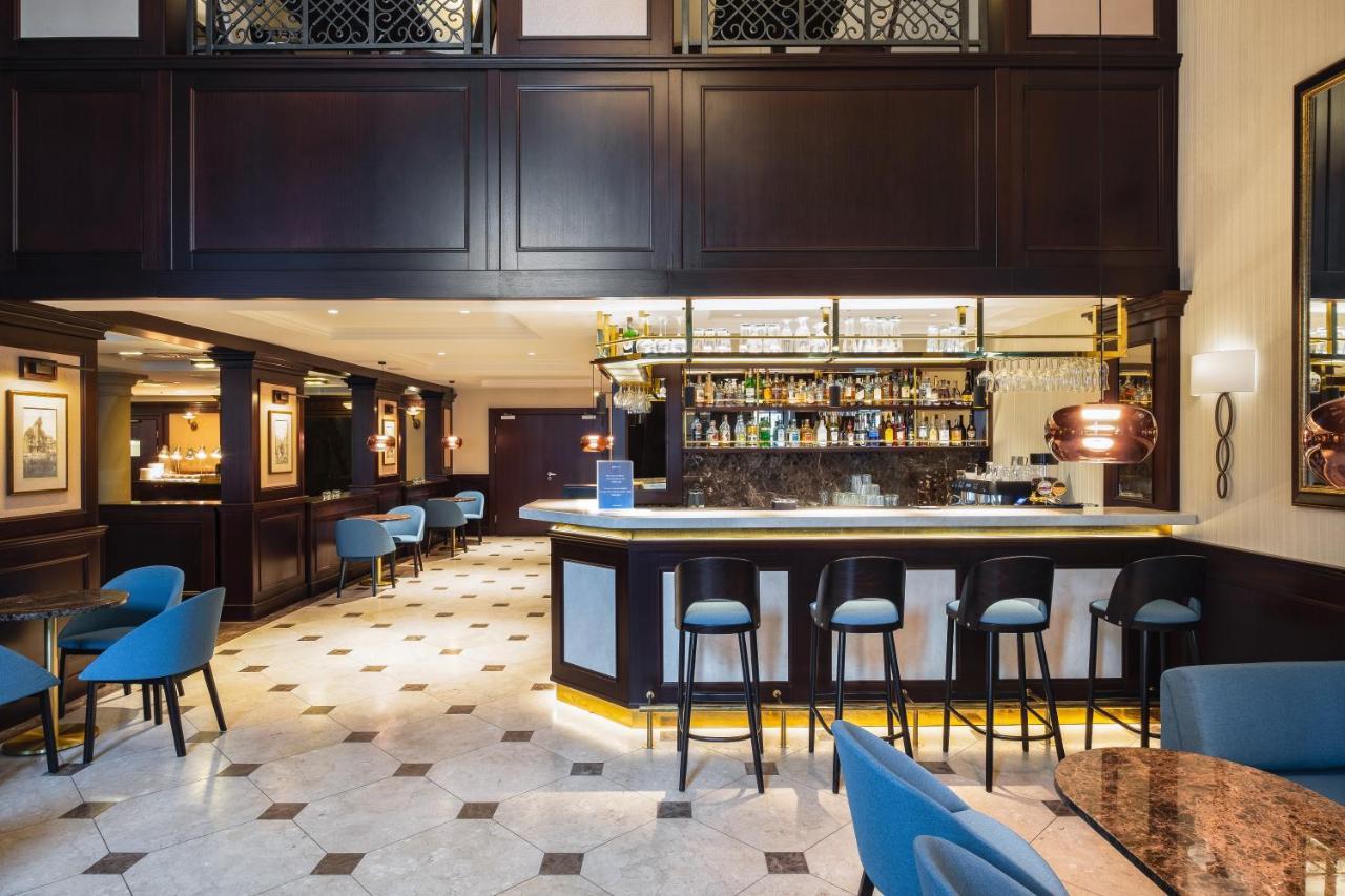 Radisson Blu Hotel, กดัญสก์ ภายนอก รูปภาพ The photo shows the interior of a bar or restaurant. It features a sleek, modern design with dark wood paneling and elegant lighting. In the center, there is a well-lit bar with a variety of bottles displayed on shelves behind it. The bar has a curve