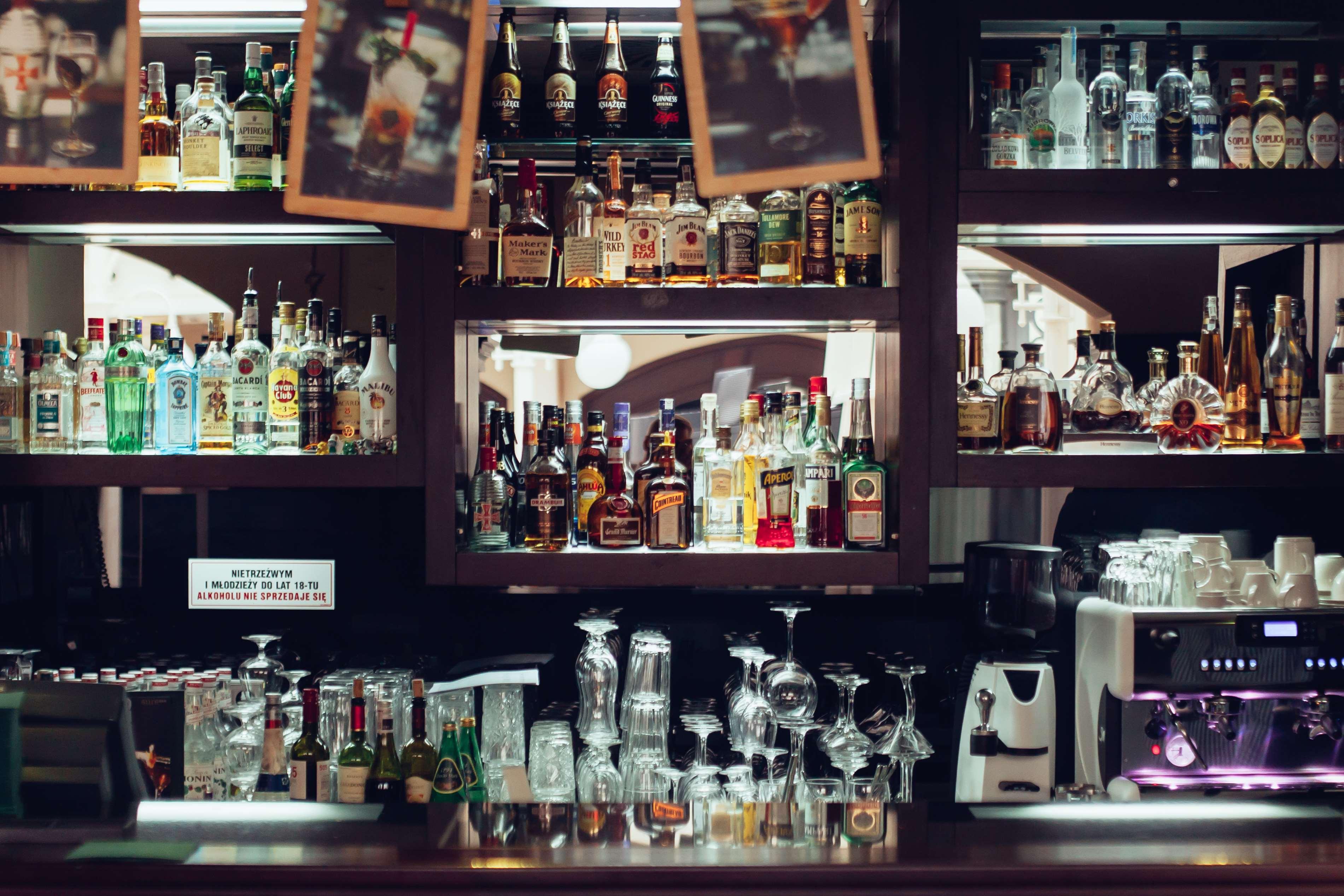 Radisson Blu Hotel, กดัญสก์ ภายนอก รูปภาพ The photo depicts a bar area featuring a wide variety of alcoholic beverages neatly arranged on shelves. The shelves are filled with bottles of different sizes and colors, including spirits and liquors. In the foreground, there are several glassware 