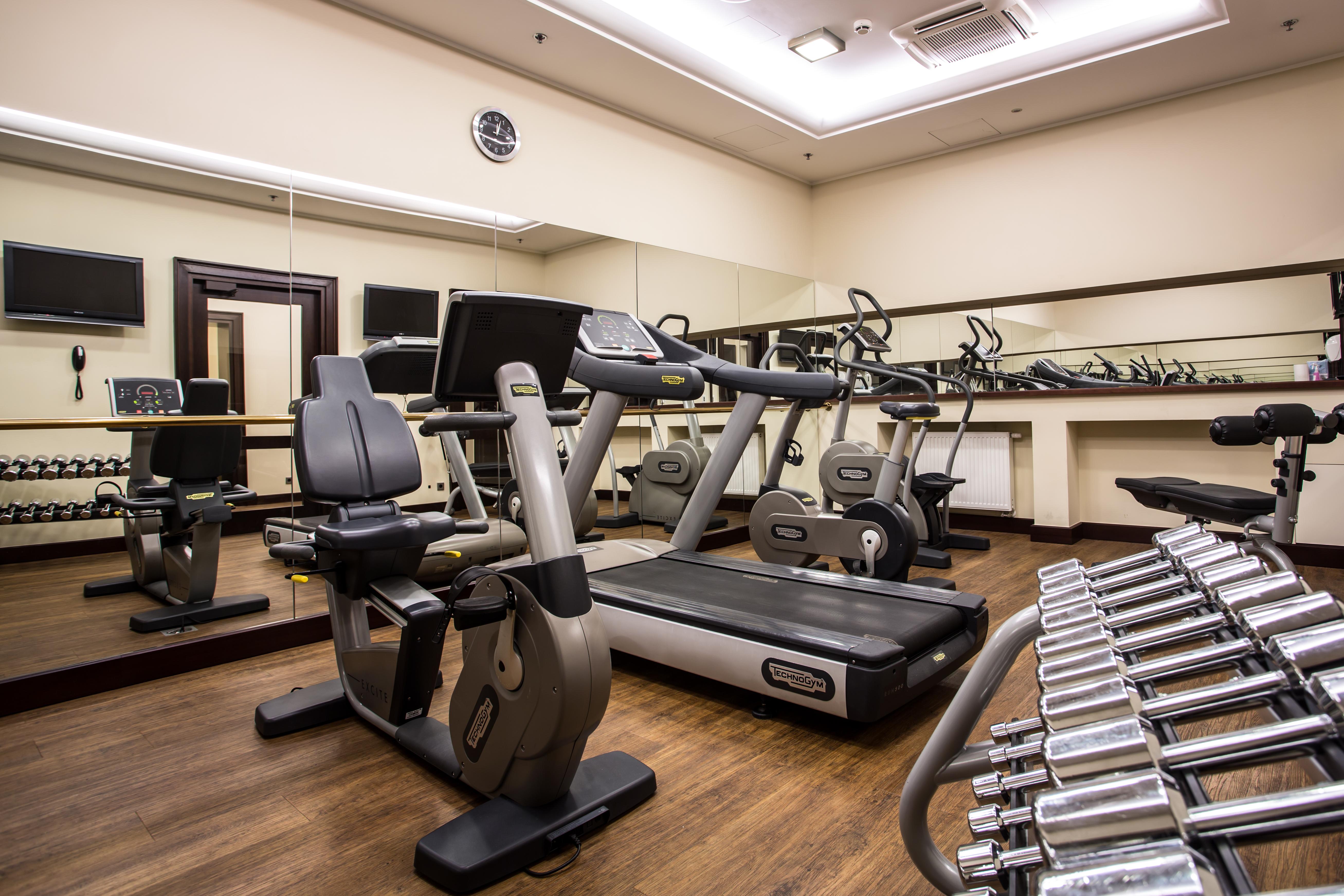 Radisson Blu Hotel, กดัญสก์ ภายนอก รูปภาพ The photo displays a small gym or fitness room. The room features various exercise equipment, including a treadmill, an elliptical machine, and a set of dumbbells arranged on a rack. There are mirrors on the wall, which help create a sense of space a